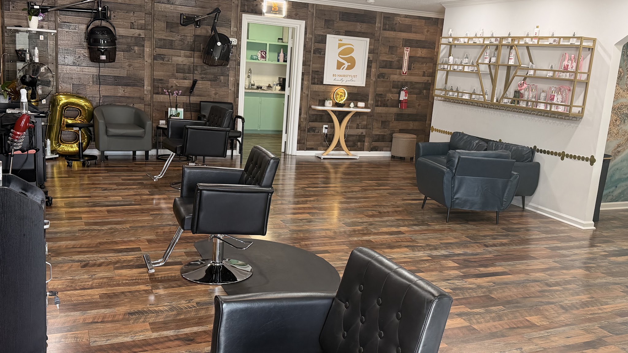Inside the salon: dark leather chairs, warm wood floors and a mint green door