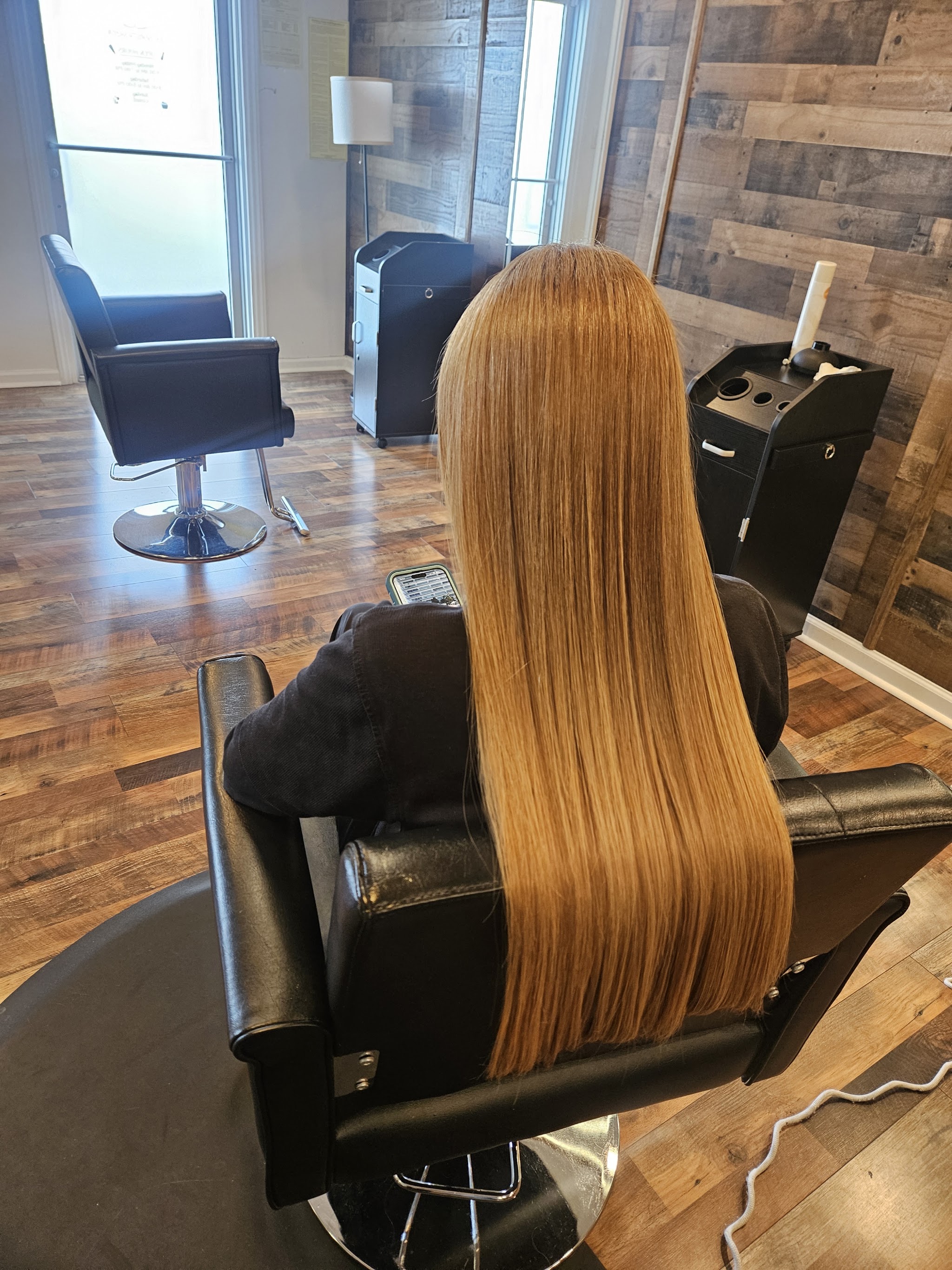 Long smooth caramel hair seen from behind in the salon chair